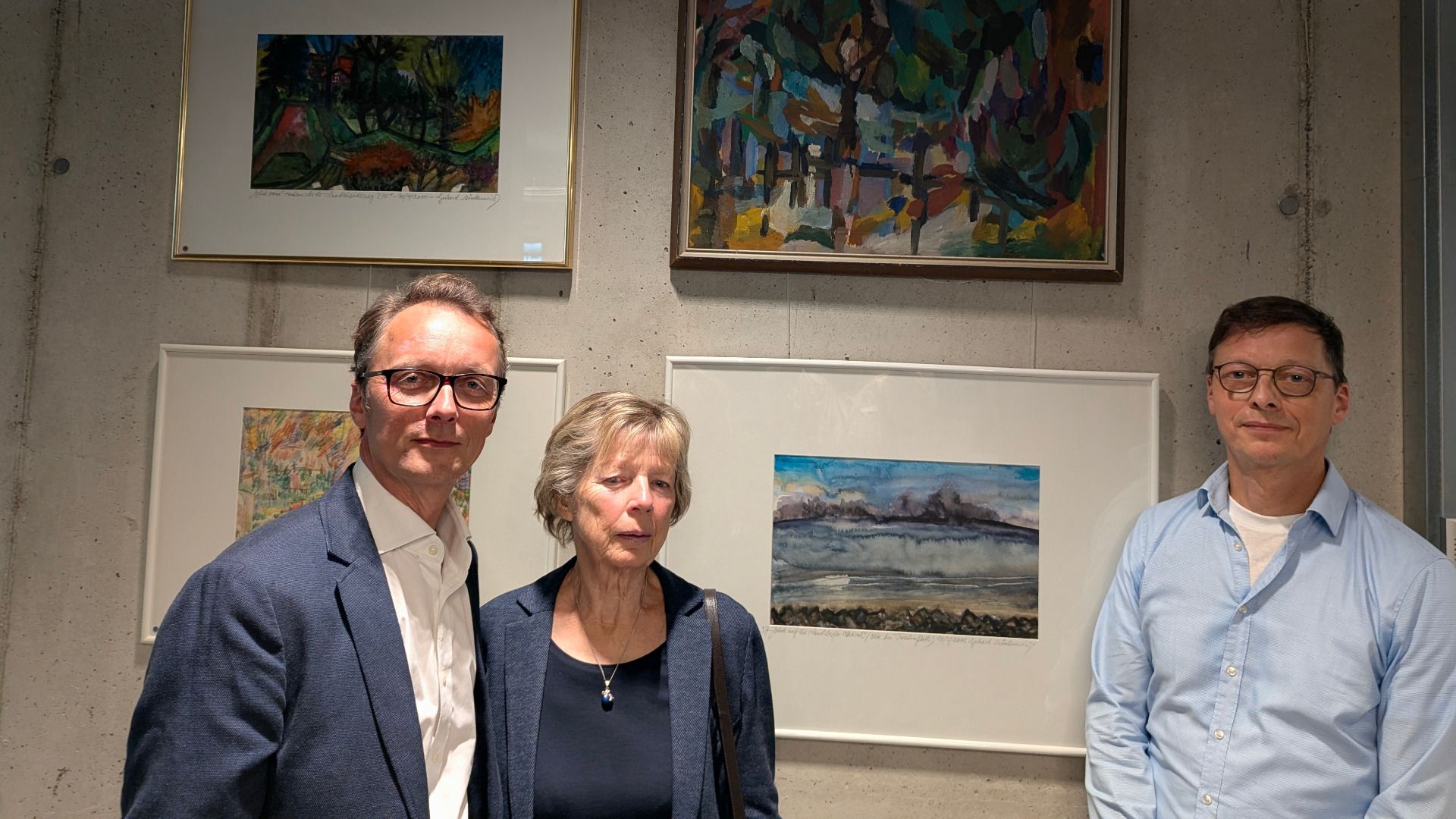 Monika Mönkemeier, Ehefrau des verstorbenen Malers Gerhard, und ihre Söhne Nils (links) und Oliver (rechts), freuen sich, dass die Gemälde wieder in der Sparkasse zu sehen sind. Foto: ein