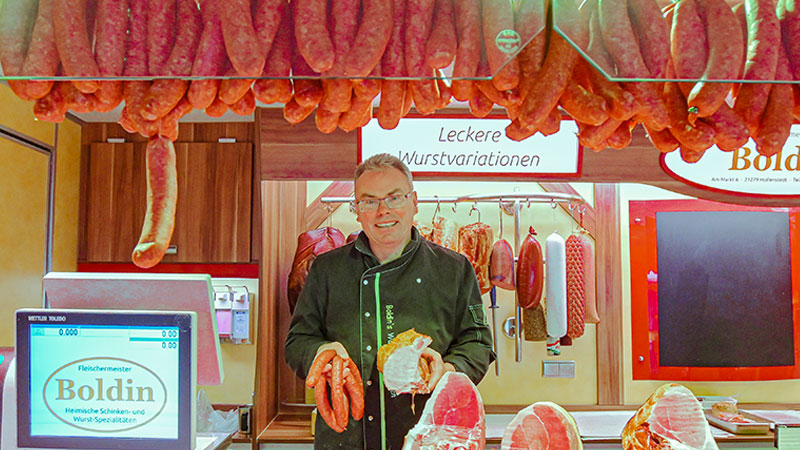 Fleischermeister Jens Boldin hat auf dem Harburger Wochenmarkt alles, was in einen guten, deftigen Grünkohl reingehört.