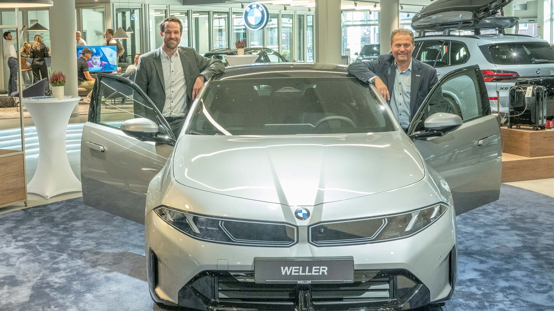 Alexander Koenen (links) und David Breuer zeigen stolz den neuen BMW i3. 