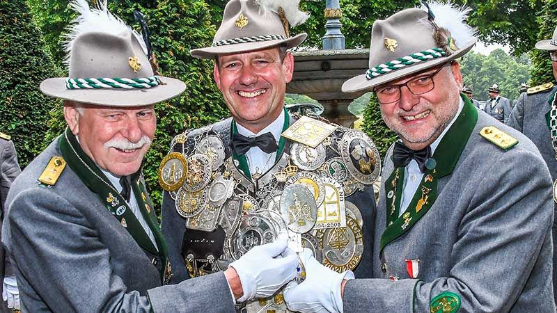 Die beiden Schaffer der Gilde, Ingo Volkland (links) und Frank Kirste (rechts) legen dem neuen König Jörg Geffke die schwere Königskette um. | Foto: Niels Kreller