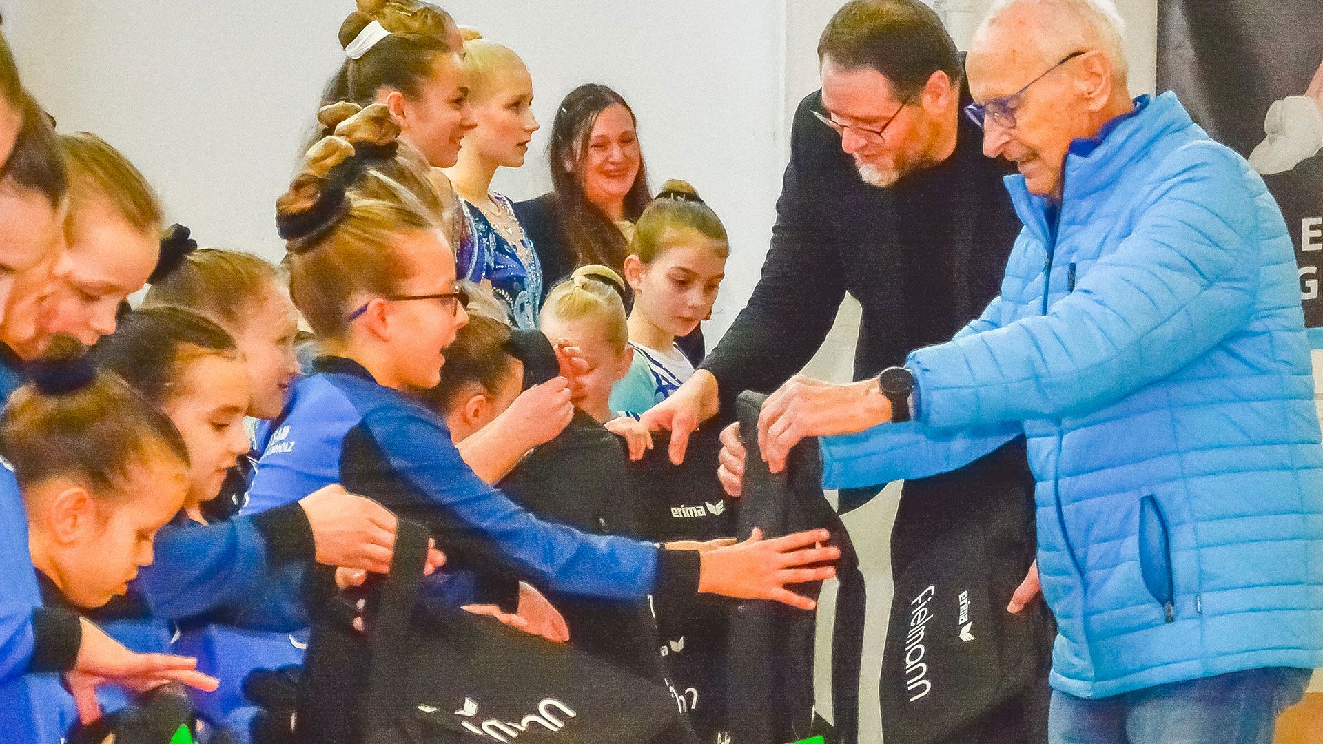 Lars Musa, Filialleiter bei Fielmann in Buchholz, übergibt mit Blau-Weiss-Chef Arno Reglitzky und Andreas Loser die Sporttaschen an das Blau-Weiss-Wettkampfteam Aerobicturnen. | Foto: ein