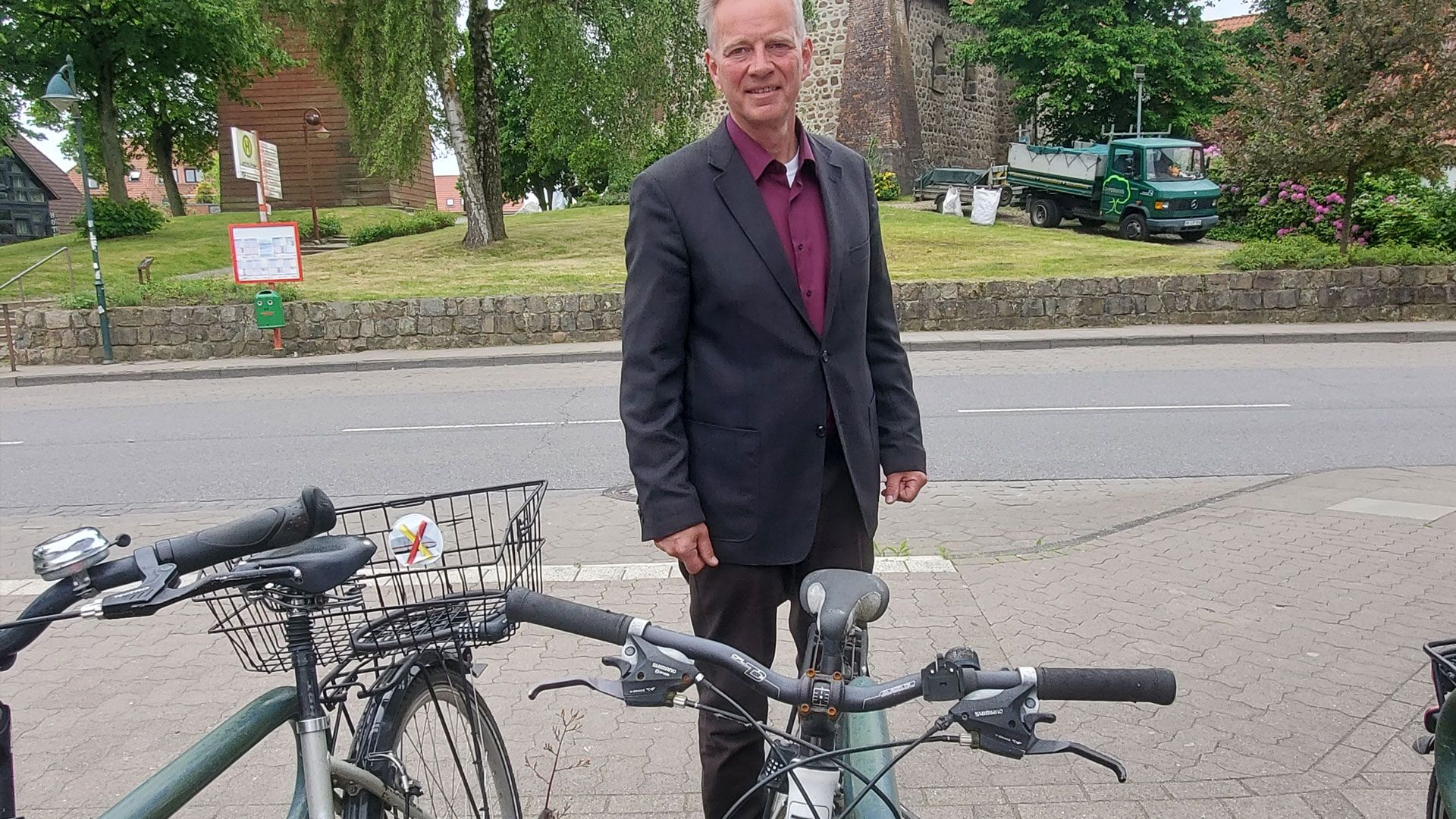 Hittfelds Ortsbürgermeister Helmut Dohrmann vor einem lange nicht mehr bewegten Fahrrad an der Bushaltestelle vor der Kirche. Foto: Christina Dohrmann sowie die entsprechende Banderole. | Foto: Gemeinde Seevetal