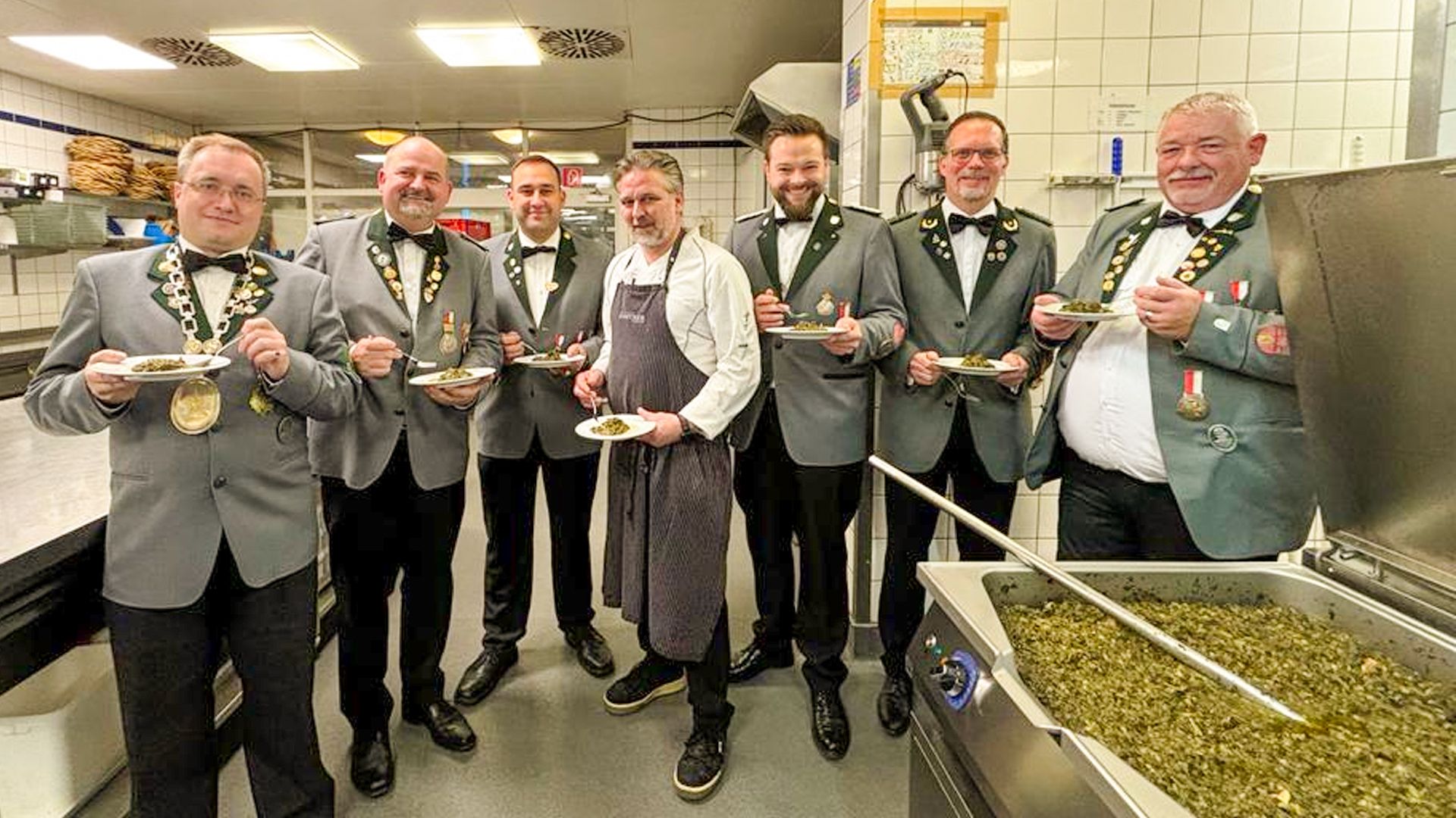 Bevor es ans Essen ging, probierten die beiden neuen „Knöpfe“ Borhen "Bo" Azzouz (3.v.l.) und Nico Ehlers (5.v.l.) mit dem Vorstand der Knöpfe, Gildekönig Ulf Schröder und Küchenchef Sebastian Lohmann den Grünkohl. | Foto: Heiko Mönke