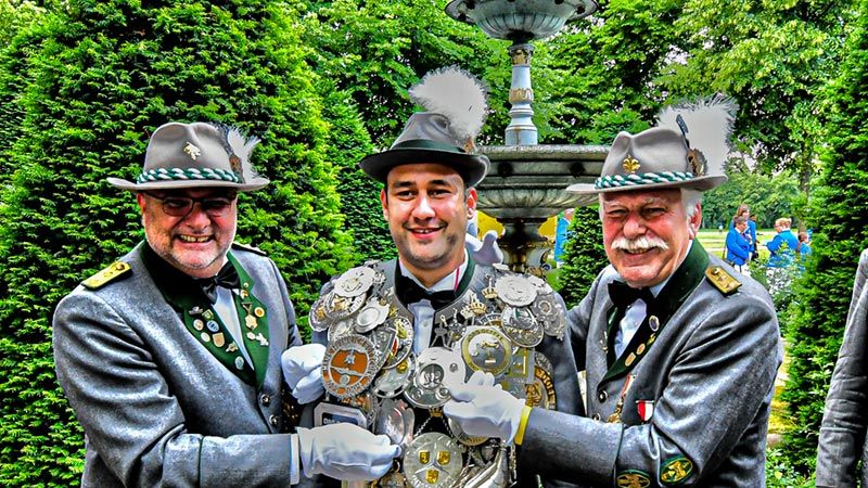 Krönender Abschluss des 491. Harburger Vogelschießens: Der neue Gildekönig Borhen "Bo" Azzouz (Mitte) bekommt von den beiden Schaffern Frank Kirste (links) und Ingo Volkland die schwere Königskette der Harburger Schützengilde umgelegt. | Foto: Niels Kreller