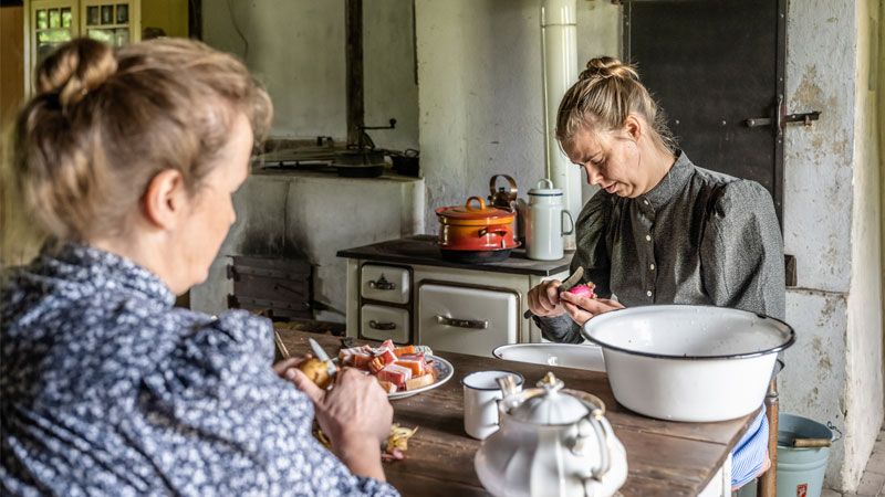 Die Fischerfamilie der "Gelebte Geschichte"-Darsteller im Freilichtmuseum am Kiekeberg beim Kartoffelschälen. | Foto: FLMK