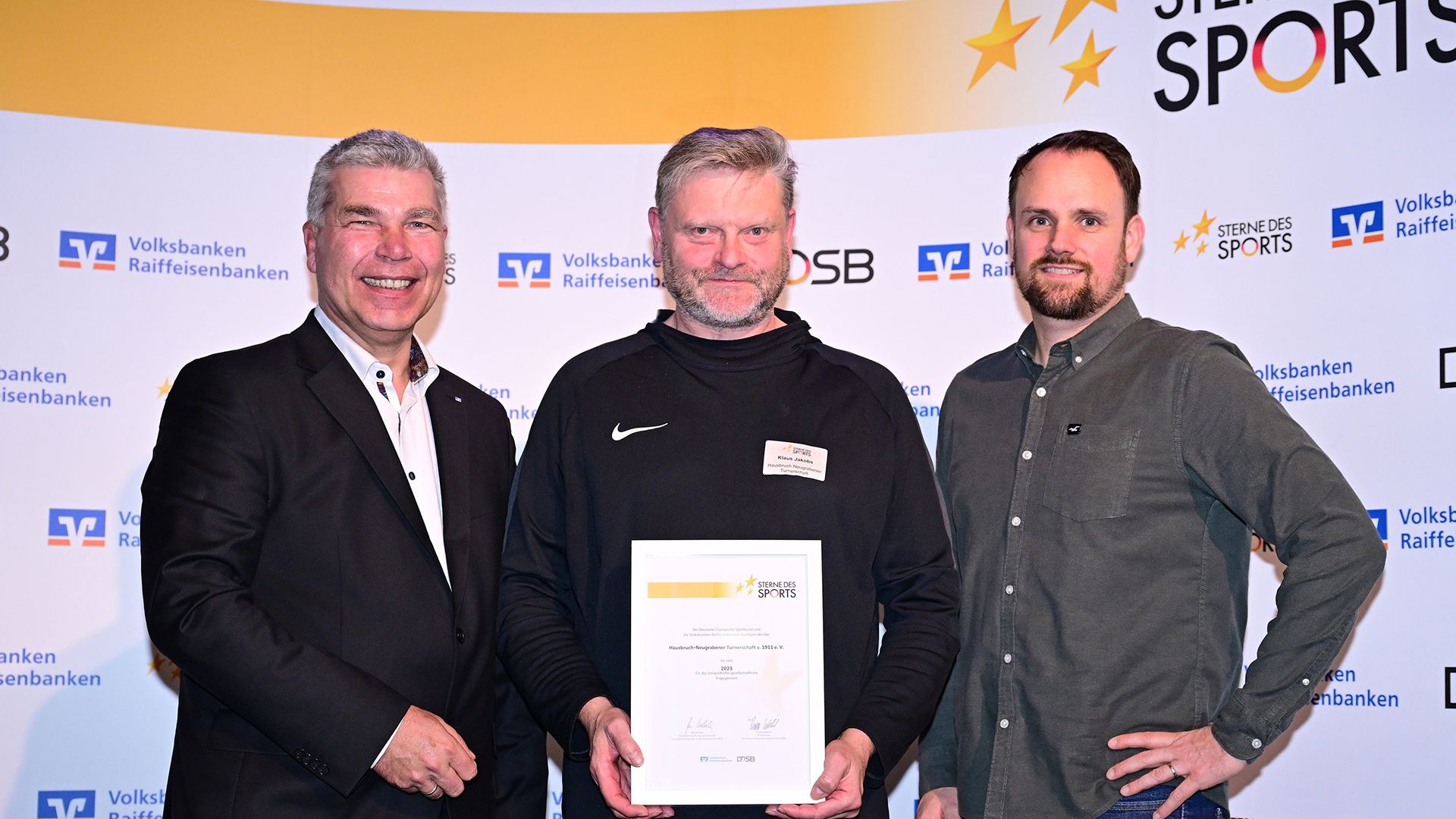 HNT-Geschäftsführer Klaus Jakobs (Mitte) bei der Ehrung mit Daniel Knoblich, Vorsitzender des Hamburger Sportbundes (rechts) und Philipp Maschmann, Volksbanken Raiffeisenbanken. | Foto: Hamburger Sportbund/HNT