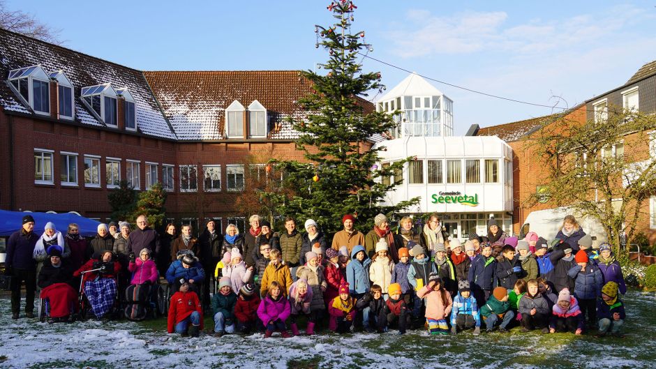 Bewohnerinnen und Bewohner des Hauses Huckfeld sowie die Kinder von drei ersten Klassen der Grundschule Hittfeld vor dem geschmückten Baum. | Foto: Gemeinde Seevetal