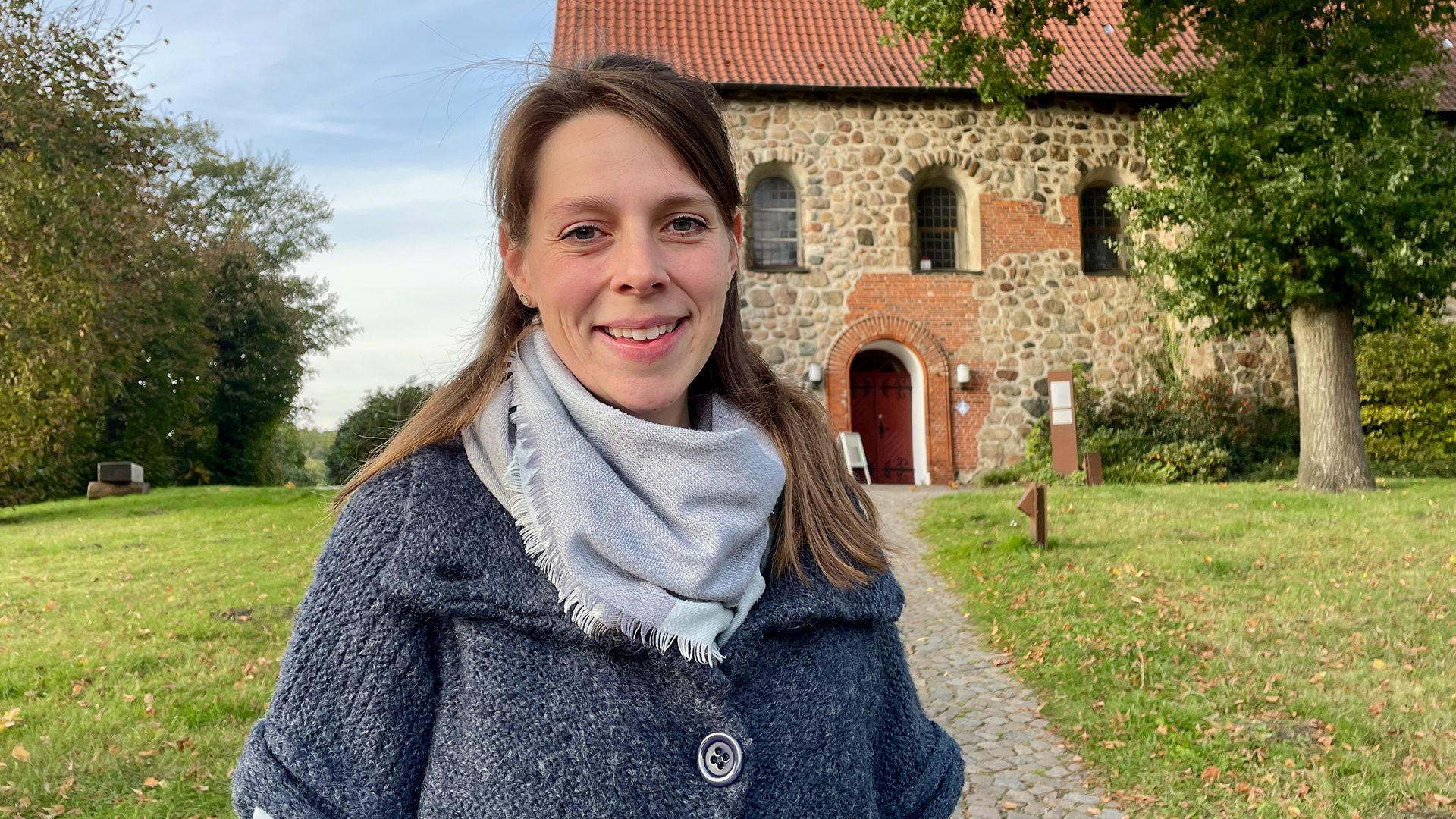 Diakonin Jana Langhof vor der Hittfelder Mauritiuskirche. | Foto: C. Wöhling