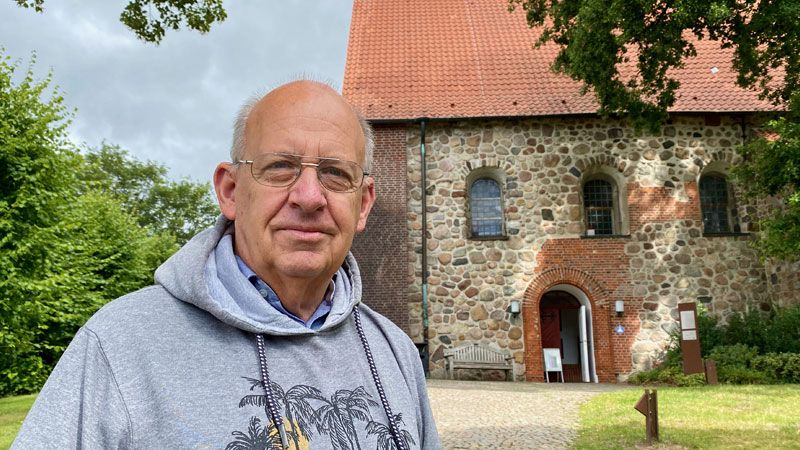 Pastor i.R. Rolf Fröhlich vor der Hittfelder Mauritiuskirche. | Foto: C. Wöhling