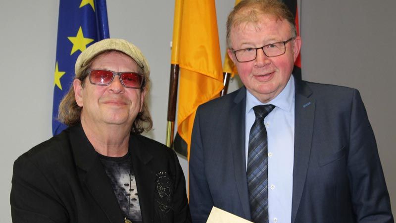Der Liebe wegen nach Deutschland gekommen, geblieben, erfolgreich geworden und nun deutscher Staatsbürger: Jean-Jacques Kravetz aus Jesteburg zeigt auf seiner Einbürgerungsurkunde, gemeinsam mit dem Stellvertretenden Landrat Rudolf Meyer, dass er in den Landkreis Harburg gehört. | Foto: ein
