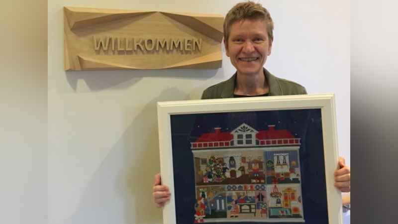 Die neue Spendenbeauftragte beim DRK Harburg, Simone Thiede, zeigt das Stickbild, das beim Adventsmarkt im Hospiz für Hamburgs Süden am 7. Dezember versteigert wird. | Foto: DRK-Kreisverband Hamburg-Harburg e.V.