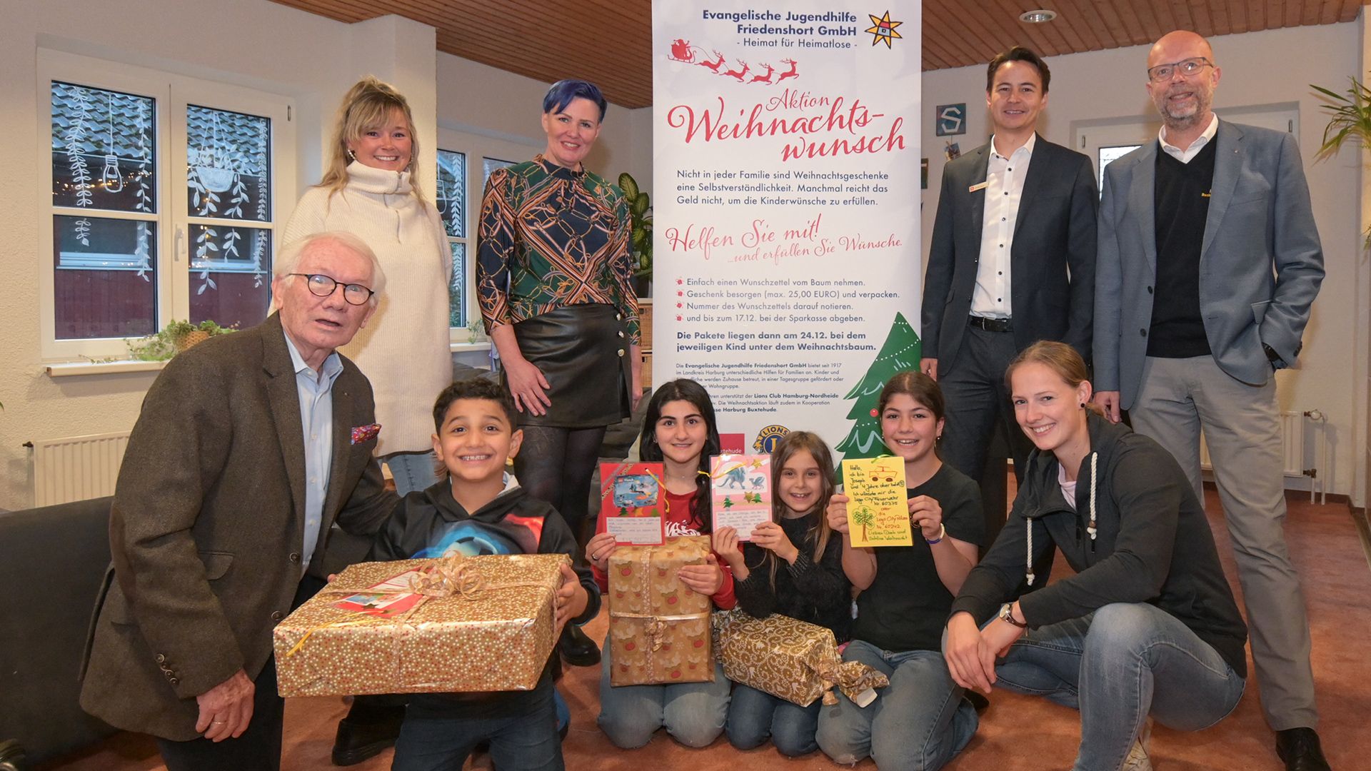 : Gemeinsame Vorfreude auf den Startschuss der Aktion Weihnachtswunsch 2023: Hinten: Sarah Fuhlbohm (von links) und Claudia Warnke (Jugendhilfe Friedenshort), Tim Beckmann (Sparkasse Harburg-Buxtehude), Thomas Wilde (Lions Club). Vorne: Bernd Baatz (von links, Lions Club) sowie Mohamed, Yasemeen, Yvonne, Armeera, Jana Pluntke (Jugendhilfe Friedenshort). | Foto: Sparkasse