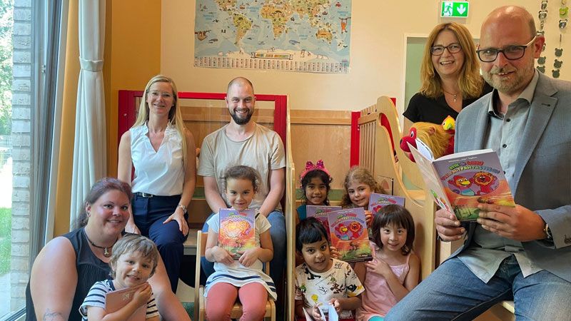 Autor Johannes „Jojo“ Tapken (rechts) gemeinsam mit Josefin Kühn (v.l.), Vorständin Natja Berg, Patrick Voss und Sandra Schmücker ließt Kindern aus der Kita Zauberwiese aus Vielfaltfantastisch vor. | Foto: ein