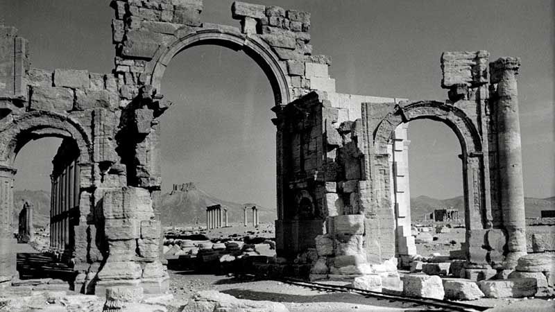 Palmyra – Das sechs Meter hohe Hadrianstor an der Kolonnadenstraße im Jahr 1960. Im Vordergrund sind Schienen zu sehen, die für die Kamera einer US-Produktion montiert wurden. | Foto: Yonne von Schweinitz