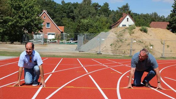 „Auf die Plätze …“ – Jörn Petersen (links), Leiter des Betriebs Gebäudewirtschaft des Landkreises Harburg, und Projektleiter Lutz Meyer demonstrieren schon einmal, dass die neuen Laufbahnen genutzt werden können. | Foto: ein