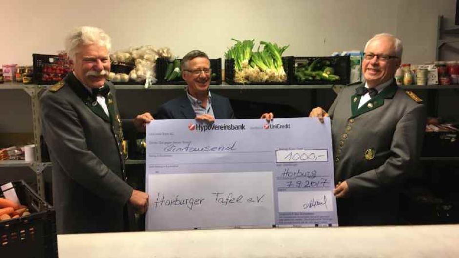 Gute Laune am Tresen der Essensausgabe der Harburger Tafen: Ingo Volkland (links) und Klaus-Jürgen Hübner (rechts) von der Harburger Schützengilde  übergeben den 1000-Euro-Scheck an Thomas Kaul. | Foto: ein