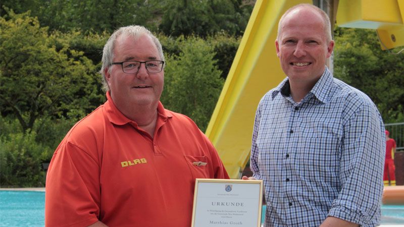 Für sein Engagement bei Neu Wulmstorfs schwimmenden Lebensrettern von der DLRG erhielt Matthias Groth nun von Bürgermeister Tobias Handtke die Ehrennadel der Gemeinde verliehen. | Foto: Gemeinde Neu Wulmstorf