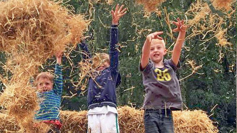 Kinder spielen beim Frühlingsfest im Wildpark Schwarze Berge im Strohnest. | Foto: Wildpark Schwarze Berge