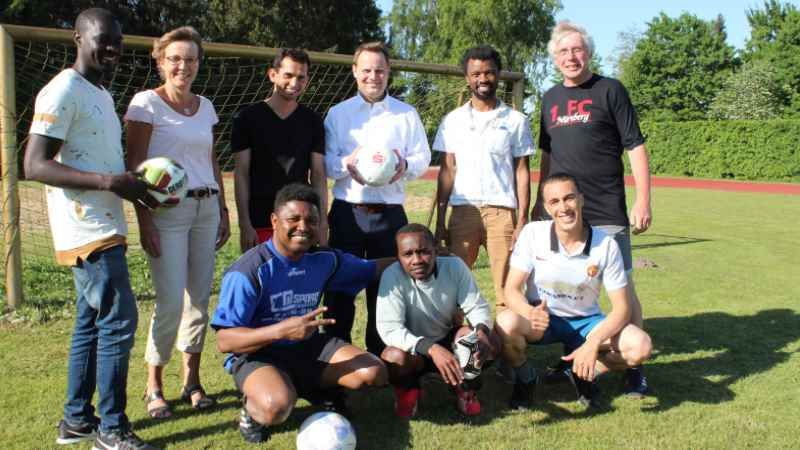 Ulrike Tschirner (Zweite von links) und Sparkassendirektor Jörn Stolle (Vierter von links) freuen sich mit Trainer und Spielern der internationalen Fußballmannschaft Winsen über deren neues Equipment. | Foto: ein