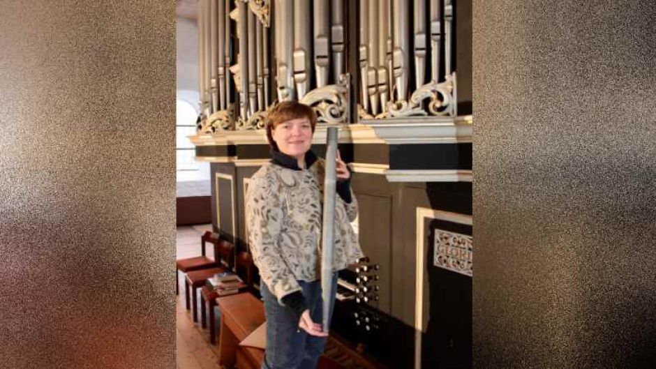 Gisela Helms vor der Hittfelder Furtwängler-Orgel mit einer Orgelpfeife. | Foto: ein
