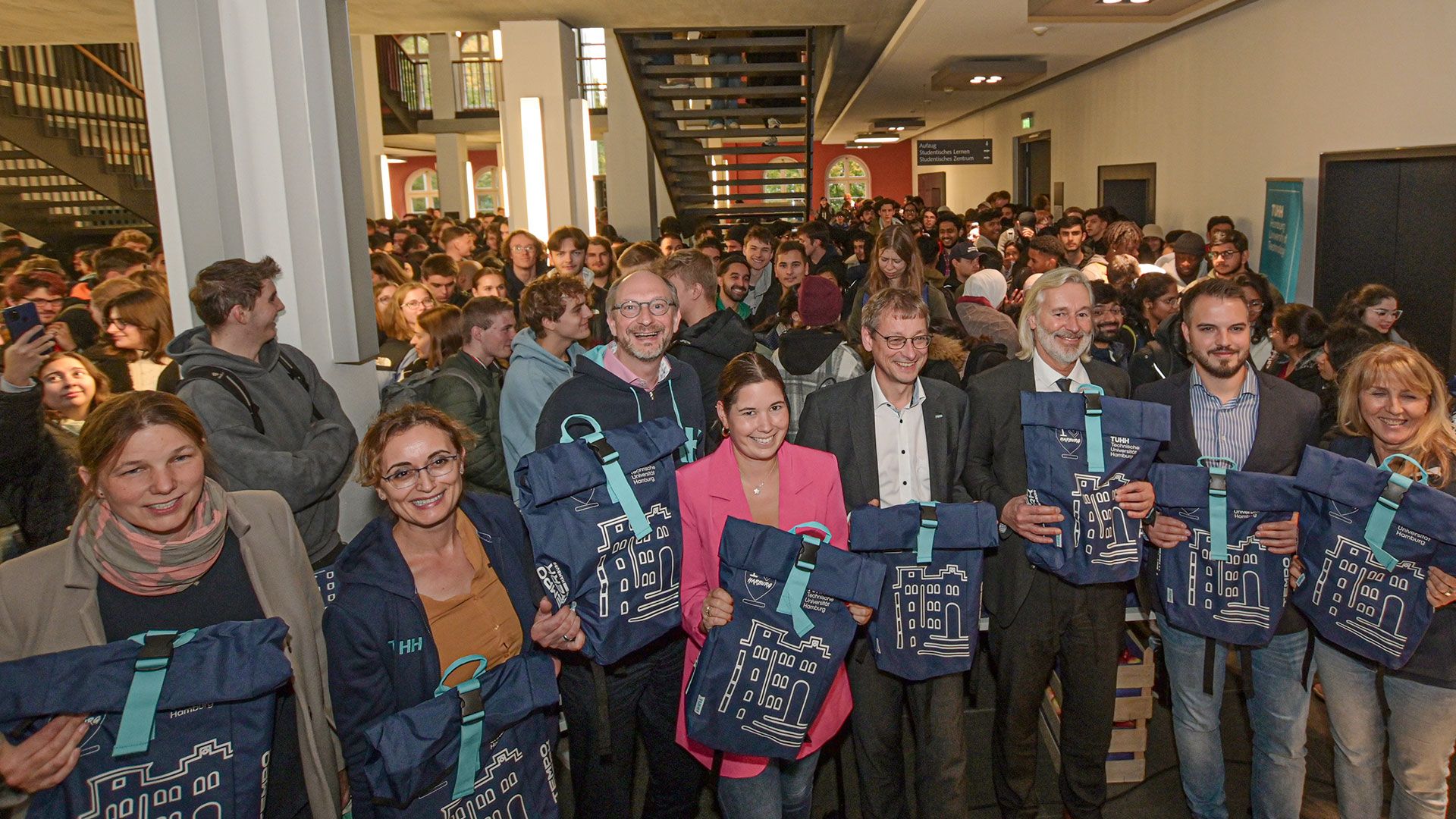 TU-Präsident Andreas Timm-Giel (Mitte, hinten) bei der Ausgabe der Ersti-Taschen an neue Studierende auf dem Campus der TU Hamburg. | Foto: Niels Kreller