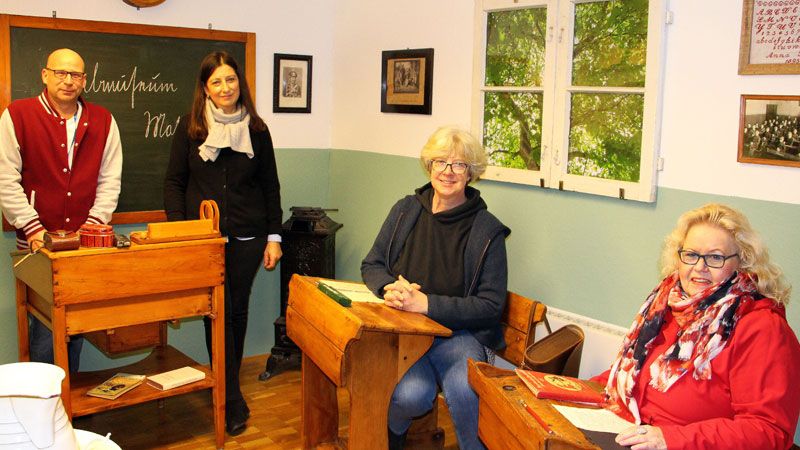 Anlässlich eines Besuchs von Seevetals Bürgermeisterin Emily Weede (Zweite von rechts) und Maschens Ortsbürgermeisterin Angelika Tumuschat-Bruhn (rechts) zeigen Rolf André (Schulleiter) und Katrin Lembke-Schlaaff (Koordinatorin Ganztag) jetzt den historischen Klassenraum – dabei drücken auch die Bürgermeisterinnen fröhlich die Schulbank. | Foto: Gemeinde Seevetal