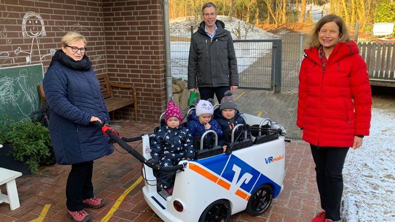 Überzeugte sich selbst von den guten Fahreigenschaften: Regionalleiter Jan Klintworth bei der offiziellen Übergabe des Kinderbusses an Kita-Leiterin Anke Jost (rechts), ihre Kollegin Silke Koch und den kleinen Fahrgästen. | Foto: Volksbank