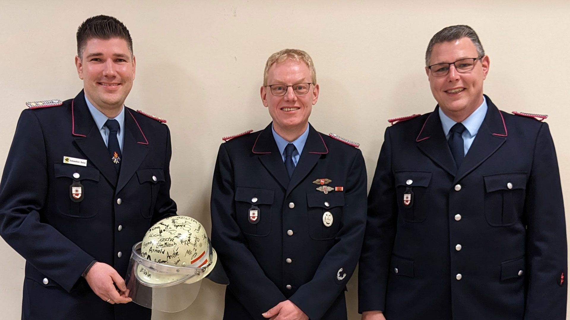 Der scheidende Ortsbrandmeister Sebastian Seier bekam einen Helm mit den Unterschriften seiner Kameraden von Ortsbm André Lübberstedt und dem neuen Ortsbrandmeister Stefan von Buchholtz überreicht. | Foto: ein