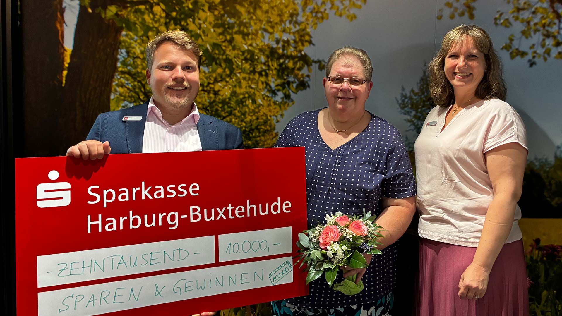 Ellen Holst (mitte) bekommt von  Regionalleiter Matty Neumann und Kundenberaterin Nadine Engel den symbolischen Gewinnerscheck überreicht. Foto: ein