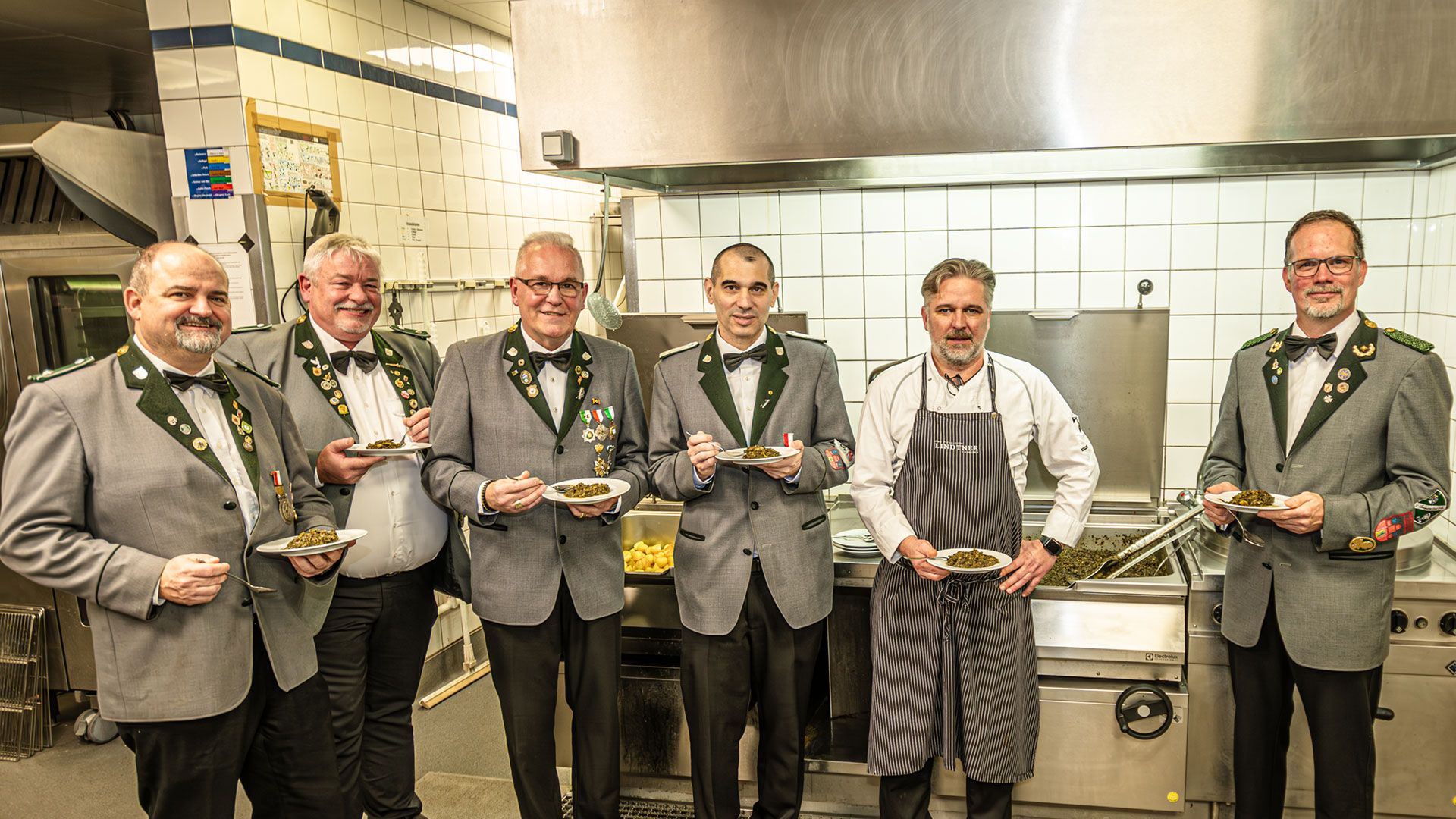 Bevor es ans Essen ging, probierten die neuen „Knöpfe“ Lothar Kestler  (3.v.l.) und Stefn Tiedke (4.v.l.) mit dem Vorstand der Knöpfe und Küchenchef Sebastian Lohmann den Grünkohl (nicht im Bild: Joachim Meinke). | Foto: Niels Kreller