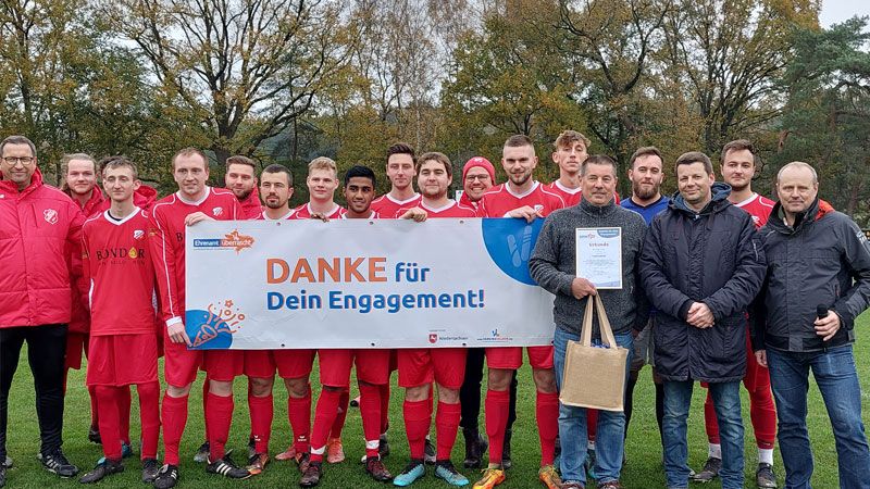 Ralf „Flaggi“ Meyke (von links), Alexander Balzer (MTV Hanstedt) und Ingo Eggers (KSB Harburg-Land) mit dem Fußball-Team des MTV Hanstedt. | Foto: Kreissportbund