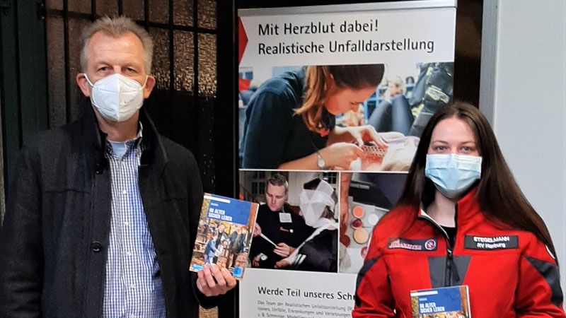 KHK Carsten Bünger zeigt zusammen mit Annika Stegelmann vom Johanniter Leitungsteam des Impfzentrums West in Buchholz das Infomrationsmaterial. | Foto: Polizei