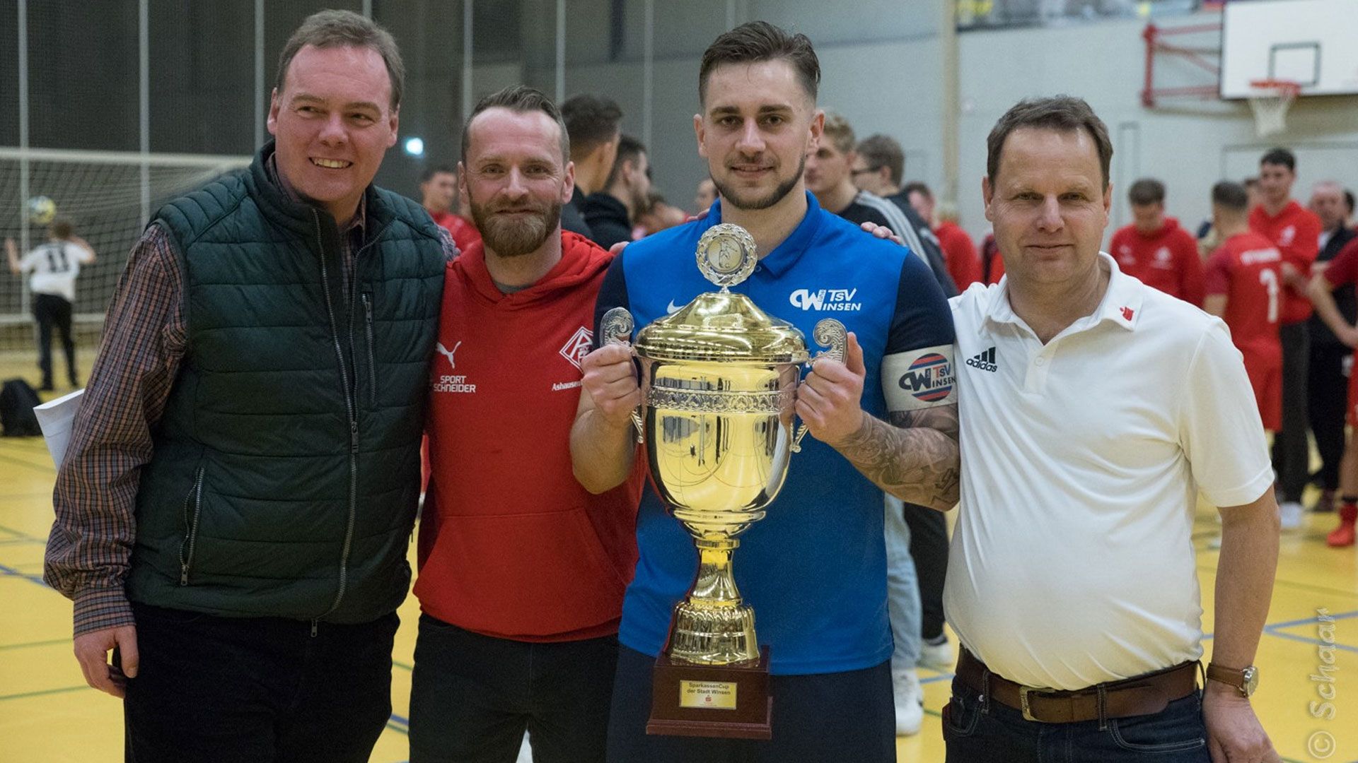 Bürgermeister André Wiese Links) und Jörn Stolle (Sparkasse Harburg-Buxtehude, rechts) mit Daniel Timm (Obmann MTV Ashausen) und Lukas Cibis, Kapitän des Turniersiegers TSV Winsen. | Foto: ein