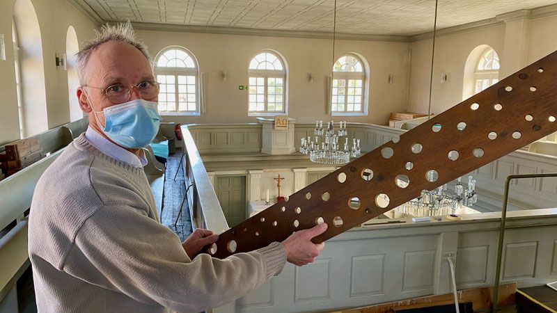 Orgelbauer Harm Kirschner hält die ausgebaute Windlade in den Händen. | Foto: C. Wöhling
