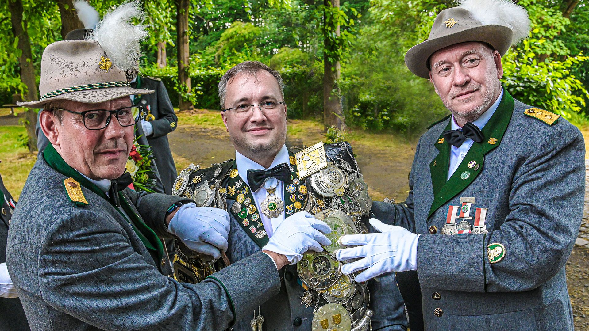 Der 1. Patron der Gilde, Ingo Mönke (rechts) und der 1. Schaffer Jörg Geffke (links) legen bei der Proklamation am Kaiserbrunnnen auf dem Scharzenberg dem neuen Gildekönig Ulf Schröder die schwere Königskette um. | Foto: Niels Kreller