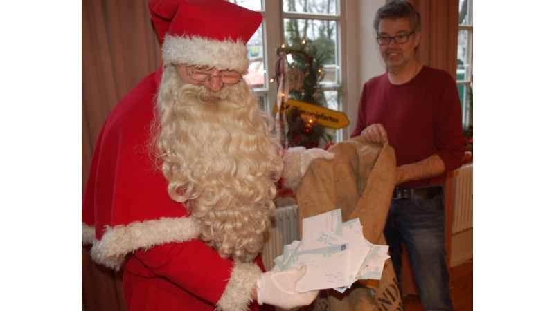 „Angekommen: Der Weihnachtsmann und der Leiter des Christkindpostamtes Himmelpforten, Wolfgang Dipper, haben die 320 Briefe aus Buxtehude entgegen genommen.“ | Foto: ein