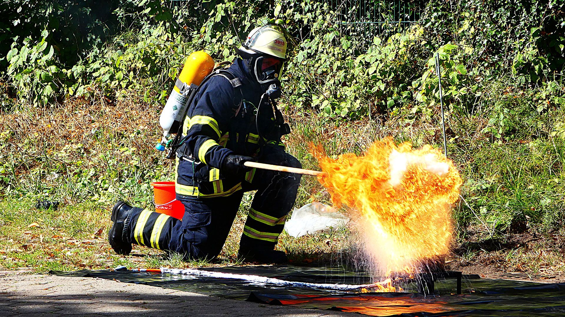Ein Feuerwehrmann der Freiwilligen Feuerwehr Sinstorf zeigt was passiert, wenn man versucht brennendes Fett mit Wasser zu löschen. Foto: Ilka Teschner