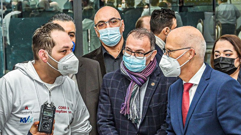 Von rechts: Hamburgs Bürgermeister Peter Tschentscher, der SPD-Bürgerschaftsabgeordnete Ali Simsek und Cemal Altun vom Stiftungssaal lassen sich von Dr. Berk Leventli vom Coronaimpfzentrum Hamburg alles zeigen. | Foto: Niels Kreller