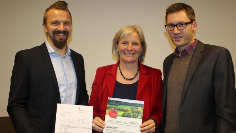 Hilke Feddersen nimmt den Zuwendungsbescheid von Dennis Rohde (links) und Torben Braun vom Amt für regionale Landesentwicklung (ArL) Lüneburg entgegen. | Foto: ein