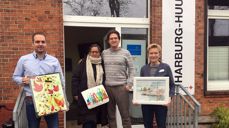 Gemeinsam mit den Gemälden „Fridolin“ und „Veritas-Kai“: Einrichtungsleiter Thorben Goebel-Hansen (von links), die Kunst- und Kulturschaffenden Ines Laqua und Ralf Schwinge und Dr. Simone Thiede (DRK Harburg). | Foto: DRK Harburg