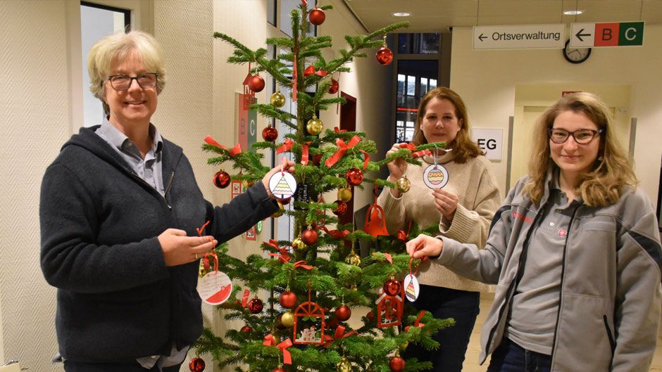 Im Rathaus Seevetal in Hittfeld schmückten Bürgermeisterin Emily Weede (von links), Sabine Strate von der Gemeinde Seevetal und Christin Darga von den Johannitern den Baum mit Wunschbaumkugel-Karten. | Foto: Johanniter