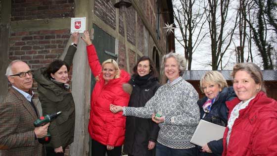Dr. Klaus Püttmann (von links), Dr. Christina Krafczyk, Martina Oertzen, Karoline Kleinert, Emily Weede, Joy Hiller, Christina Dohrmann beim Anbringen des neuen niedersächsischen Denkmalschilds an der Wassermühle Karoxbostel. | Foto: ein