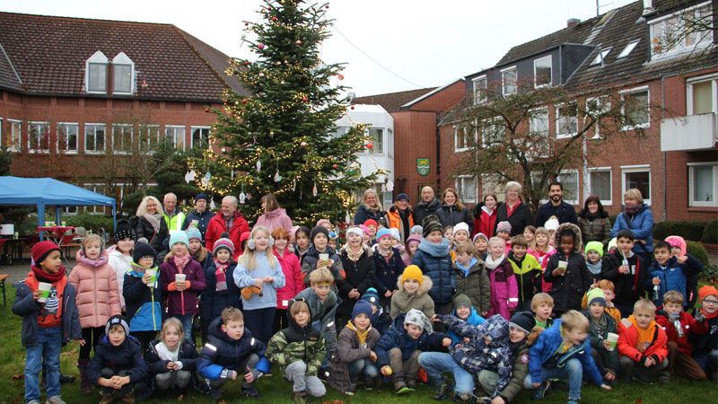 Bewohnerinnen und Bewohner des Hauses Huckfeld sowie die Kinder der drei ersten Klassen der Grundschule Hittfeld vor dem geschmückten Baum. | Foto: Gemeinde Seevetal