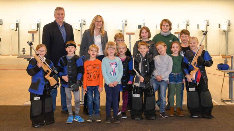 Der Vereinsvorsitzende Helwig Schwartau (links) und Sparkassendirektorin Sandra Becker (Zweite von links) bei der Trainingseinheit der jüngsten Neuenfelder Sportschützen. | Foto: ein