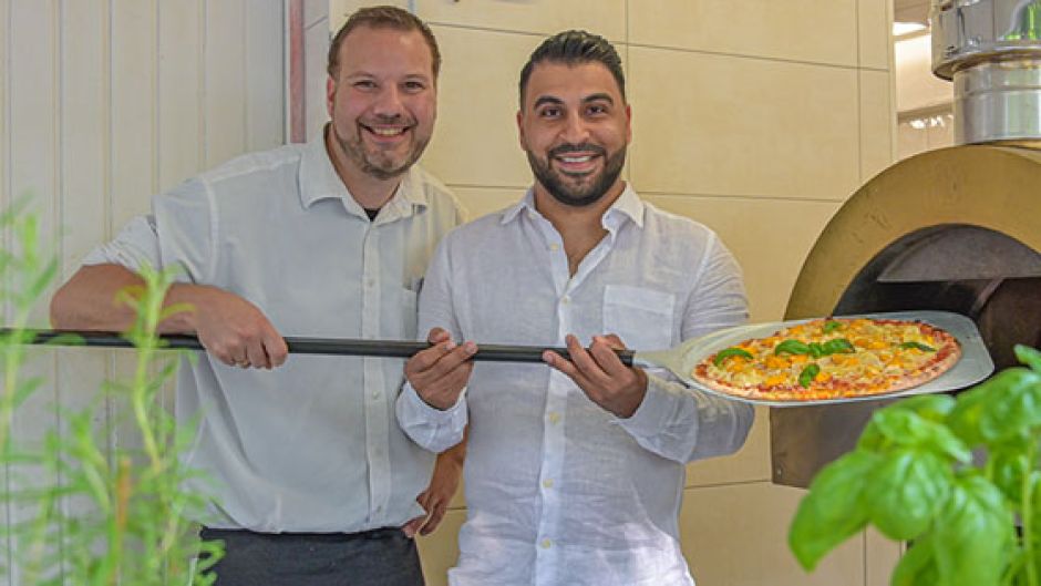 Marmstorfs Schützenkönig Sebastian „Basti“ Winter (links) und Zamim Shah freuen sich über die neue Steinofenpizza im Nova Restaurant in Marmstorf.