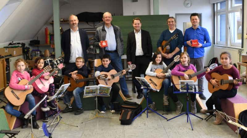 Mit den Schülern der Grundschule „AlteStadtschule“ in Winsen freuen sich Schulleiter Stefan Pleß (von links), Prof. Ab Koster, Sparkassen-Regionaldirektor Jörn Stolle, Gitarrenlehrer Dimitrios Tsimipidis und Musikschulleiter Michael Nix. | Foto: ein