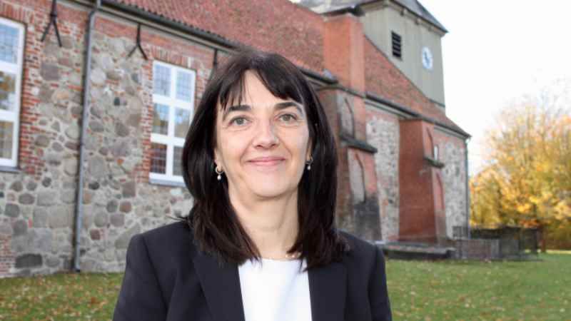 Pastorin Sabine Krüger vor der Hollenstedter St. Andreaskirche. |  Foto: ein