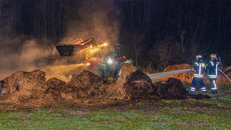 Ein Landwirt zog die Strohballen mit seinem Traktor auseinander, damit alle Glutnester gelöscht werden konnten. | Foto: JOTO