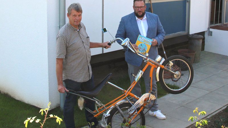 S. Zimmermann (links) mit Bonanza-Bibel und J. Maltzan mit Bonanza-Rad vor neuem Quelle-Haus am Kiekeberg. | Bild FLMK