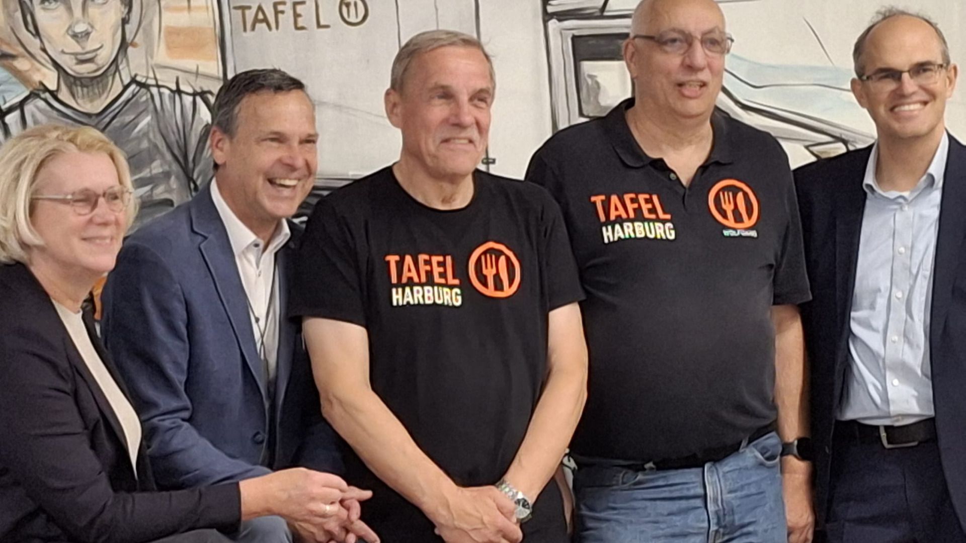 Vor dem Wandbild von Bernd muss freuen sich Birgit Stöver, Bert Stoklossa (Präsident des Harburger Rotary-Clubs), Thomas Rode und Wolfgang Naujoks (Tafel) und Bezirksamzsleiter Christian Carstensen über die Erfolgsgeschichte der Harburger Tafel. Foto: ein